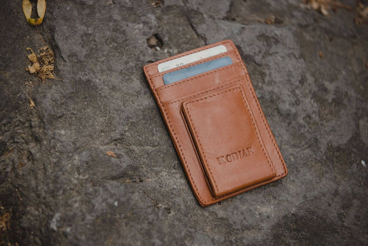 Brown leather wallet with card holder on a textured stone surface