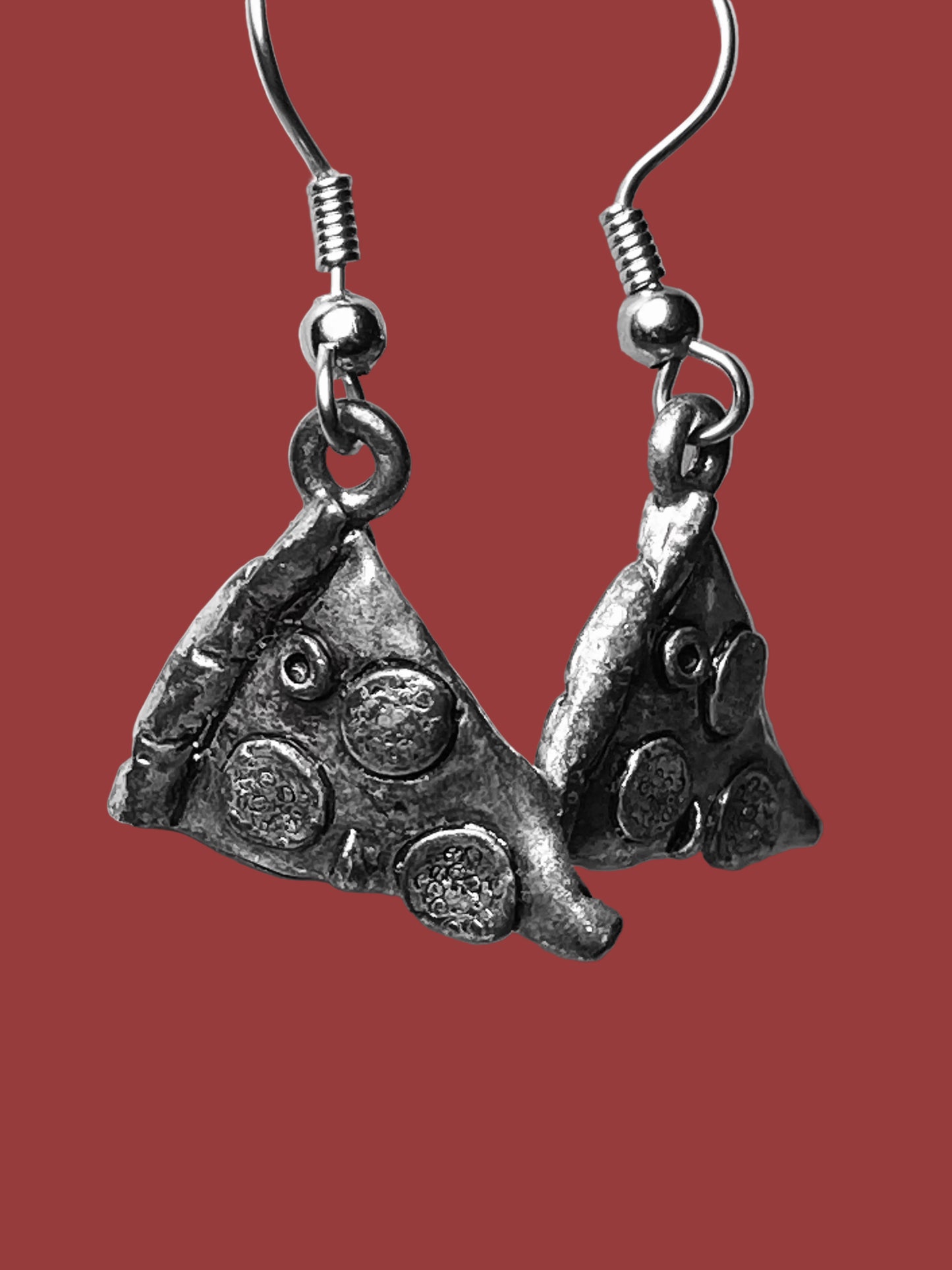 Silver pizza slice earrings on a white background