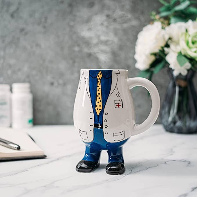 Mug shaped like a person in a suit with a tie on a marble surface.