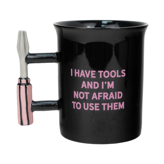 Black mug with a tool-shaped handle and pink text on a white background