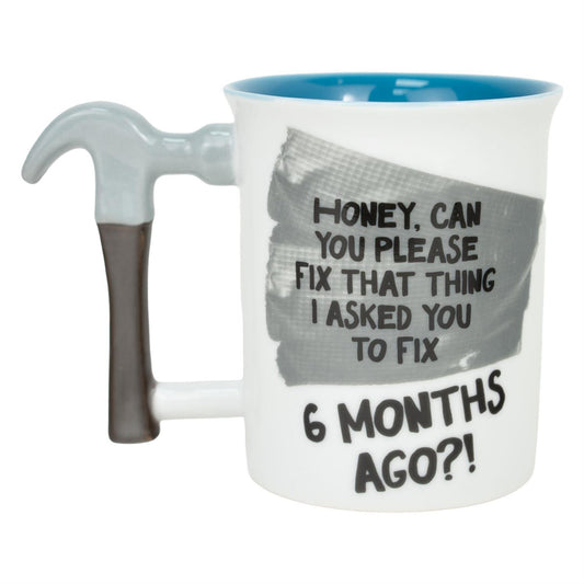 Mug with a humorous message and a tool handle on a white background