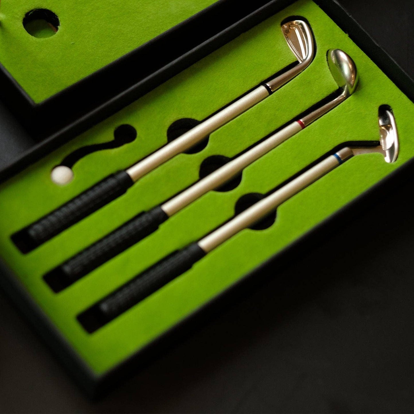 Set of golf clubs on a green mat with a black border