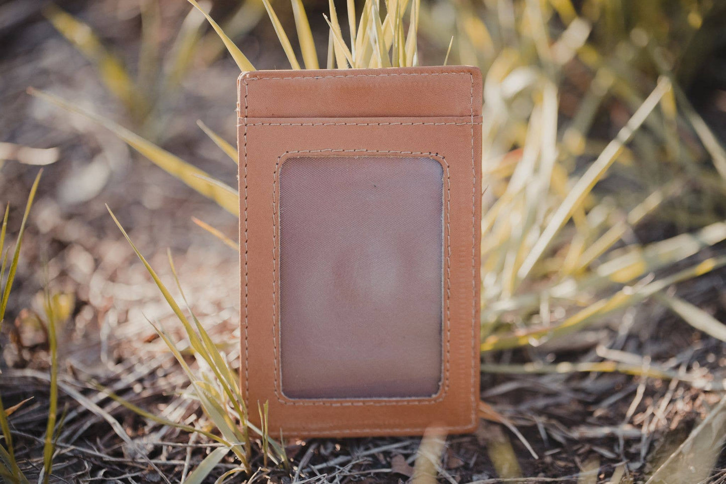 Brown leather cardholder on a grassy background