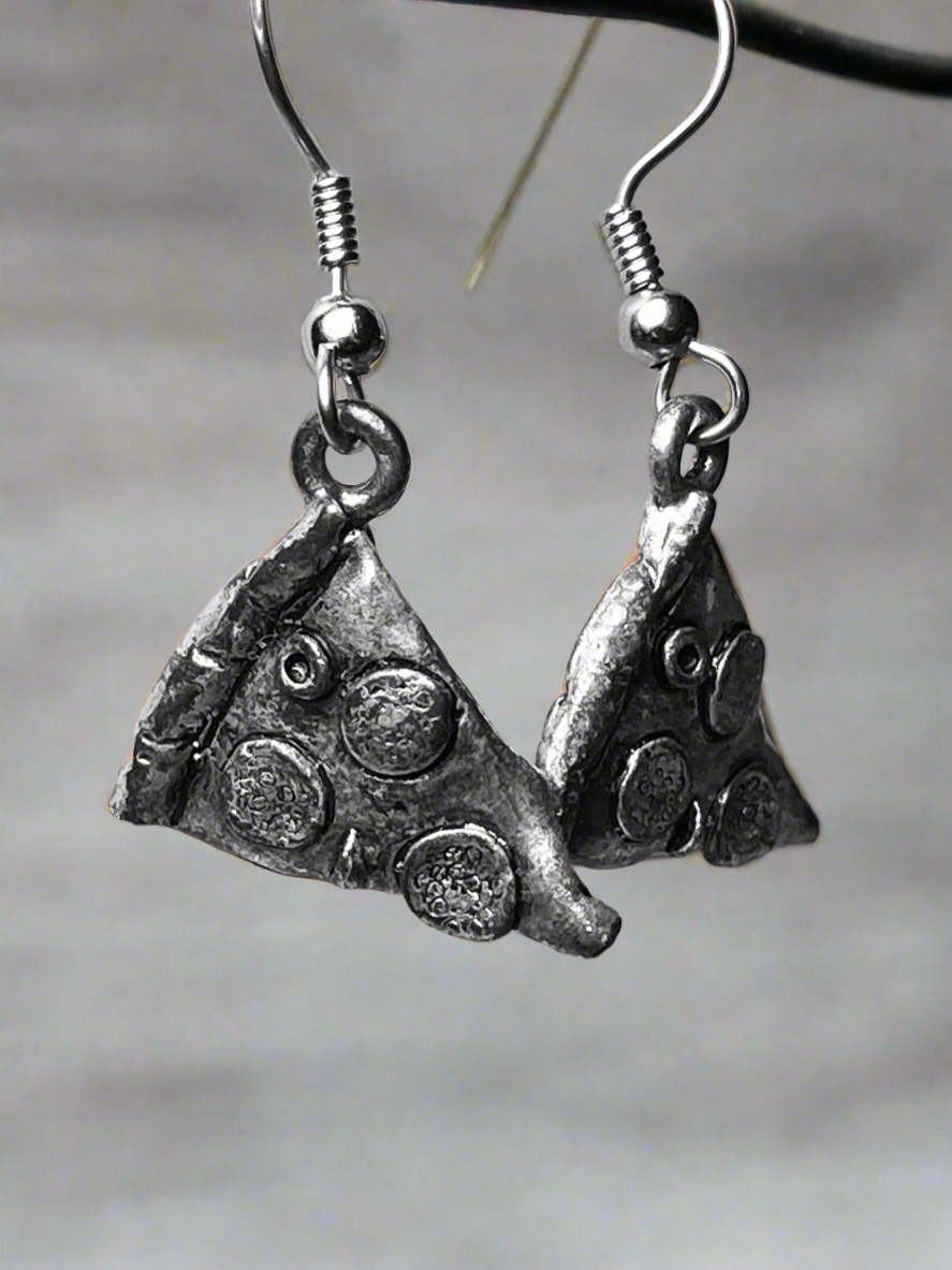Silver pizza-shaped earrings on a neutral background