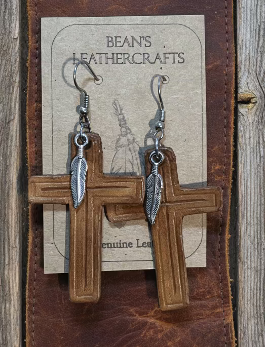 Brown leather earrings with a small silver father attached